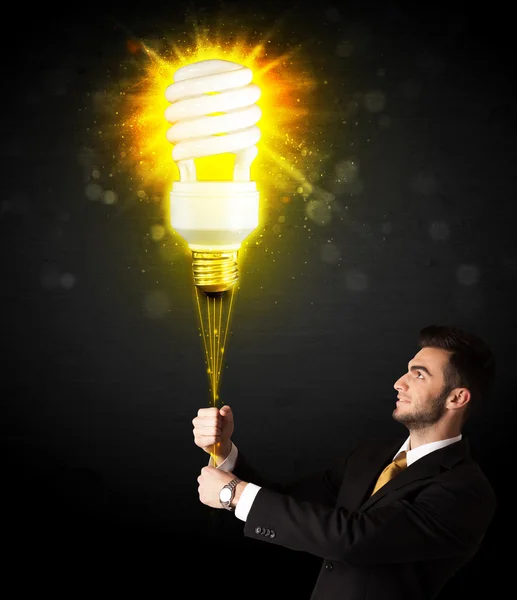Empresário com uma lâmpada eco-friendly — Fotografia de Stock
