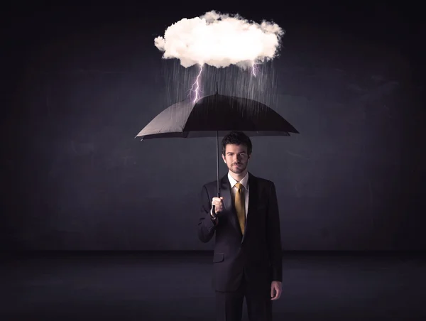 Empresário de pé com guarda-chuva e pouca nuvem de tempestade — Fotografia de Stock