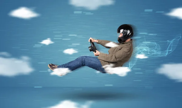 Funny racedriver jeune homme conduite entre les nuages concept — Photo