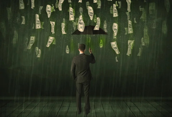 Businessman standing with umbrella in dollar bill rain concept — Stock Photo, Image