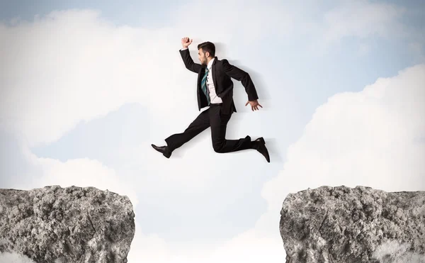 Funny business man jumping over rocks with gap — Stock Photo, Image