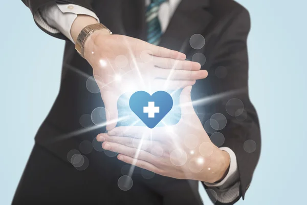 Hands creating a form with heart blue cross — Stock Photo, Image