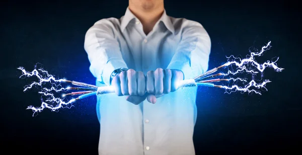 Business person holding electrical powered wires — Stock Photo, Image