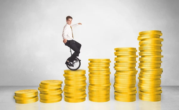 Business man riding monocycle up on coin graph — Stock Photo, Image
