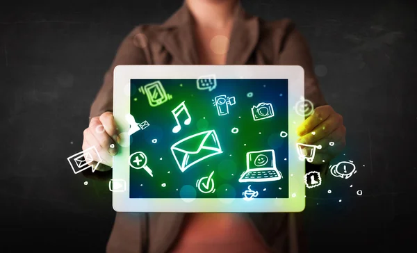 Person holding a tablet with media icons and symbols — Stock Photo, Image