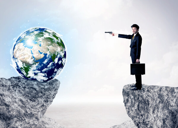 Businessman on rock mountain with a globe