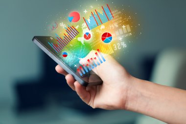 İşadamı elinde grafik sembollü akıllı telefon tutuyor.