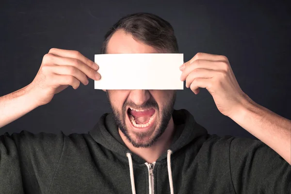 Hombre guapo sosteniendo papel de copia espacial en su ojo —  Fotos de Stock