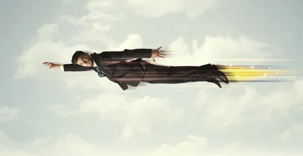 Happy business man flying fast on the sky between clouds — Stock Photo, Image