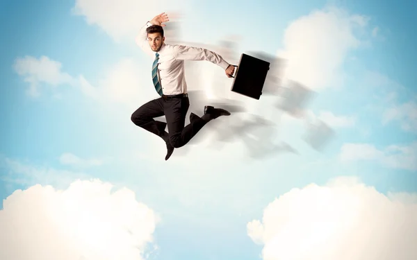 Ділова людина стрибає через хмари в небі — стокове фото
