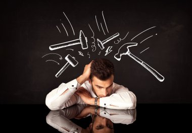 Depresyondaki işadamı çekiç izlerinin altında oturuyor