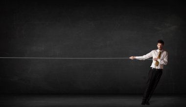 İş adamı gri arka planda ip çekiyor