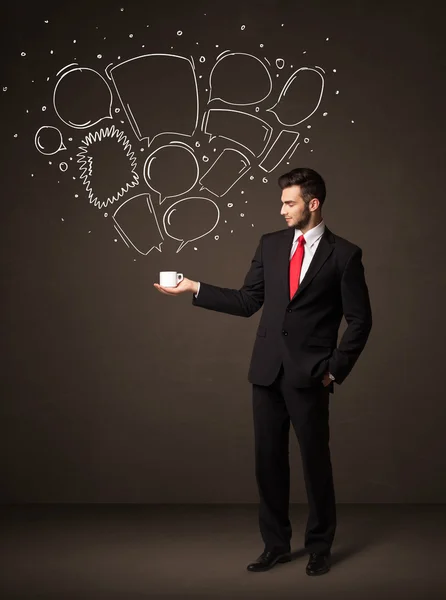 Бізнесмен тримає білу чашку з бульбашками мовлення — стокове фото