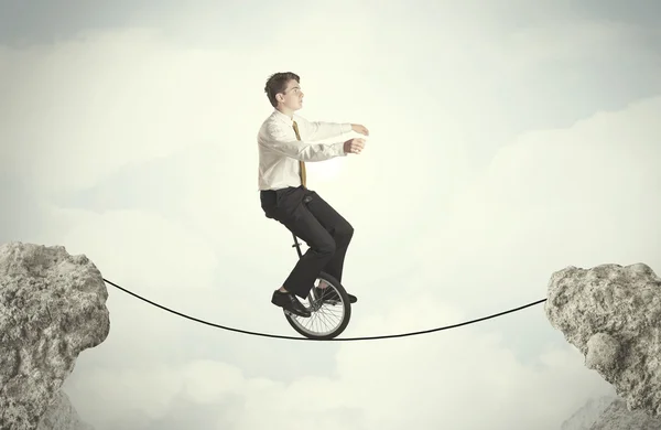 Coraggioso uomo d'affari cavalcando un monociclo tra scogliere — Foto Stock