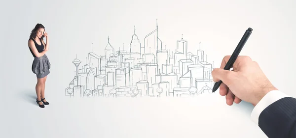 Businesswoman looking at hand drawn city on wall — Stock Photo, Image