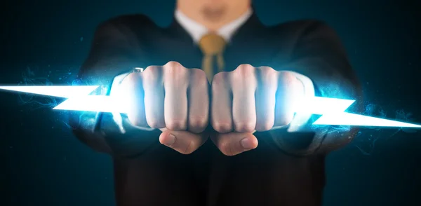 Business man holding glowing lightning bolt in his hands — Stock Photo, Image