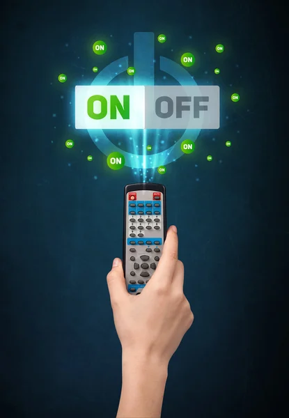 Hand with remote control and on-off signals — Stock Photo, Image
