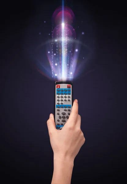 Hand with remote control and shining numbers — Stock Photo, Image