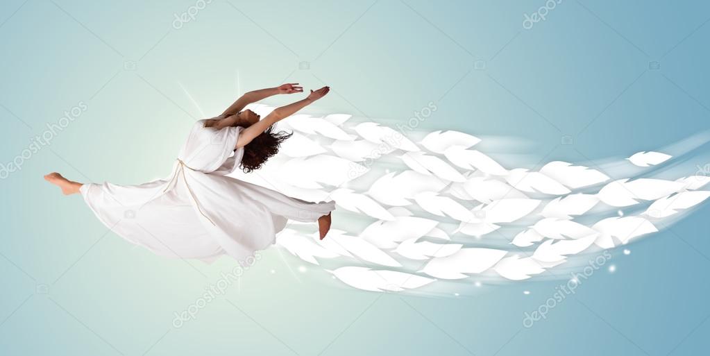 Healthy young woman jumping with feathers around her