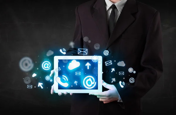 Persona sosteniendo una tableta con iconos y símbolos de tecnología azul —  Fotos de Stock