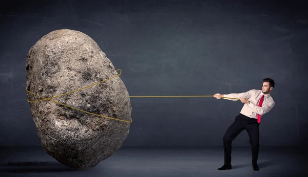 Businessman pulling huge rock with a rope — Stock Photo, Image