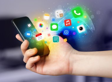 Renkli uygulama simgeleriyle el ele tutuşan akıllı telefon