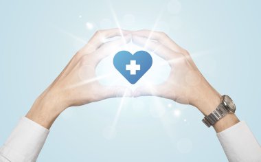 Eller mavi haçlı bir kalp yaratıyor.