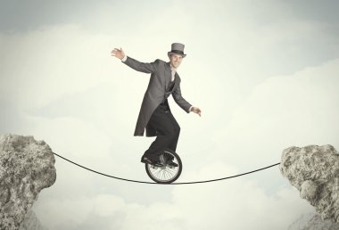 Uçurumlar arasında tekli bisiklet süren cesur bir iş adamı.