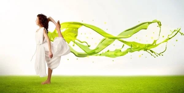 Hübsches Mädchen springt mit grünem abstrakten flüssigen Kleid — Stockfoto