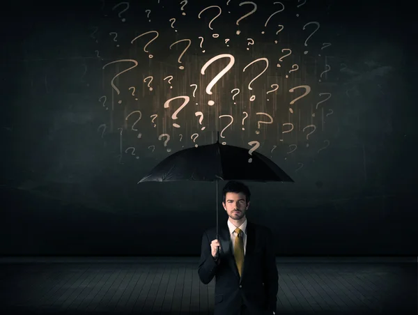 Businessman with umbrella and a lot of drawn question marks — Stock Photo, Image