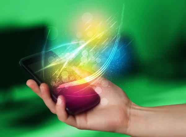 Ręczne trzymanie smartfona z abstrakcyjnymi, świecącymi liniami — Zdjęcie stockowe