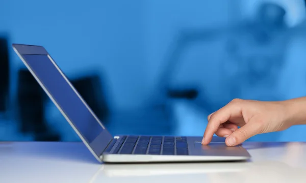 Empresário pressionando computador portátil moderno em backgrou colorido — Fotografia de Stock