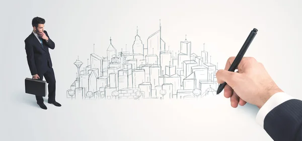 Businessman looking at hand drawn city on wall — Stock Photo, Image