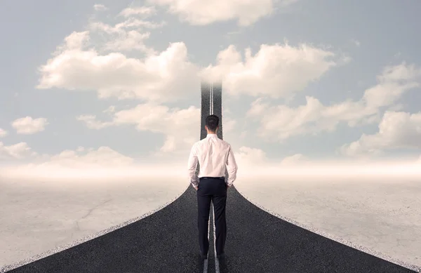 Businessman looking at 3d road that goes up in the sky — Stock Photo, Image