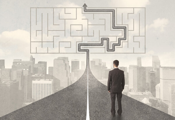 Бизнесмен смотрит на дорогу с лабиринтом и решением