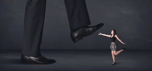 Riesenmann tritt auf eine kleine Geschäftsfrau ein — Stockfoto