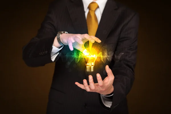 Businessman holding light bulb — Stock Photo, Image