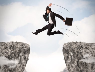 Komik iş adamı kayaların üzerinden atlıyor.