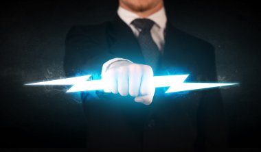 İşadamı elinde parlayan bir şimşek tutuyor.