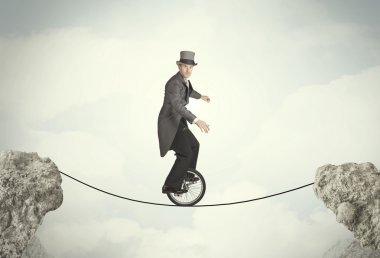 Uçurumlar arasında tekli bisiklet süren cesur bir iş adamı.
