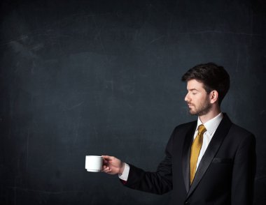 Beyaz bir bardak tutan işadamı