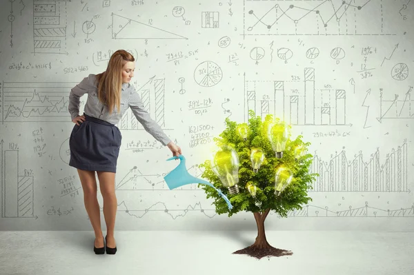 Business woman pouring water on lightbulb growing tree — Stock Photo, Image