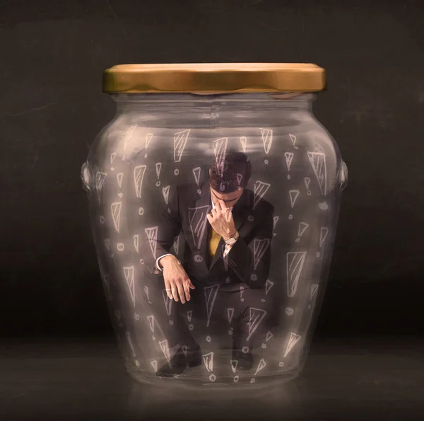 Business man trapped in jar with exclamation marks concept — Stock Photo, Image