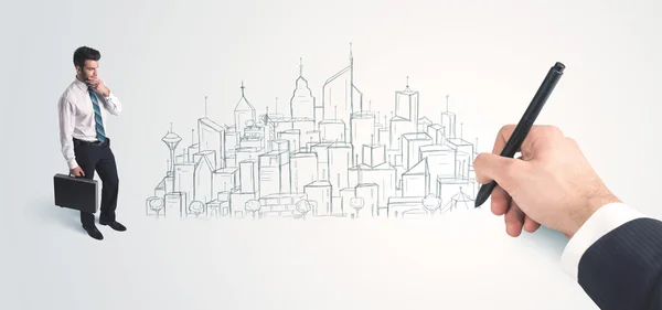 Businessman looking at hand drawn city on wall — Stock Photo, Image