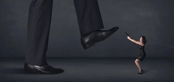 Giant person stepping on a little businesswoman concept — Stock Photo, Image