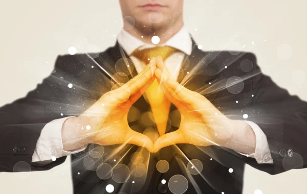 Hands creating a form with yellow shines — Stock Photo, Image