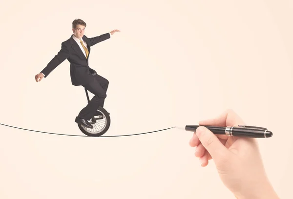 Businessman riding monocycle on a rope drawn by hand — Stock Photo, Image