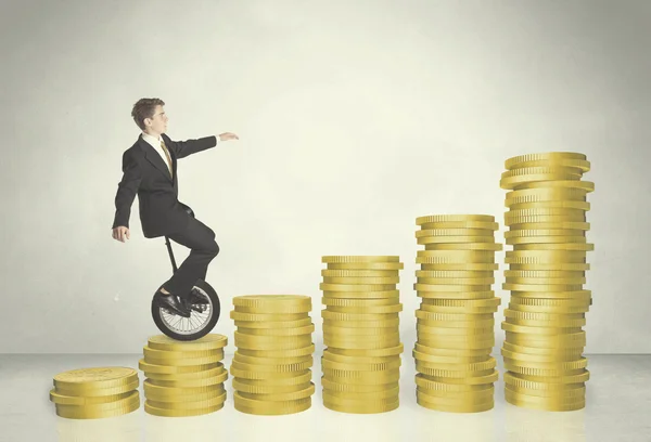 Biznes człowiek jazda monocykl się na wykresie monet — Zdjęcie stockowe