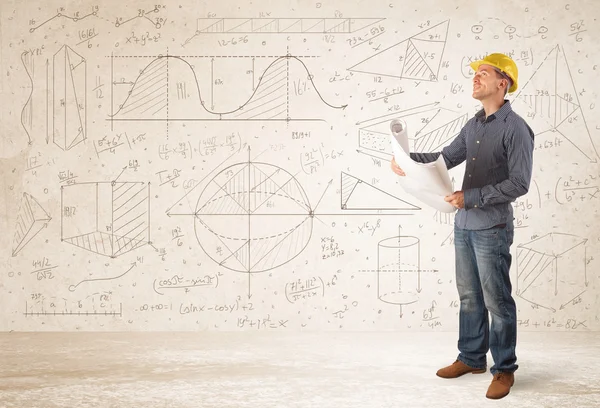 Handsome engineer calculating with hand drawn background — Stock Photo, Image