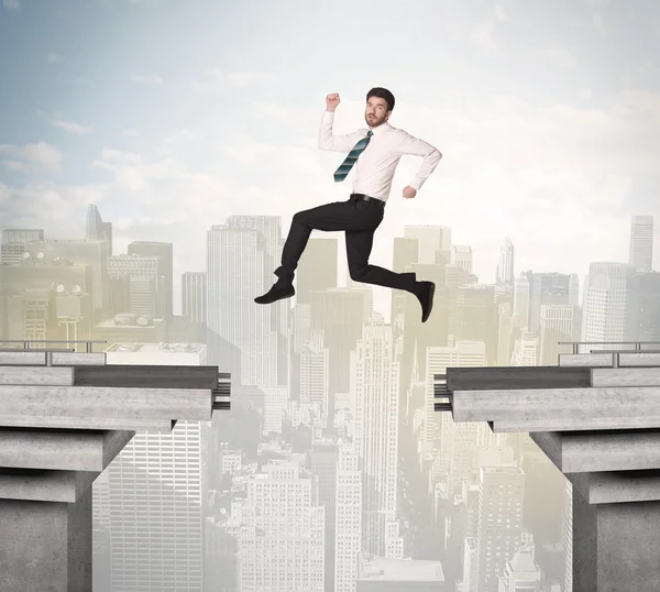 Energetic business man jumping over a bridge with gap — Stock Photo, Image